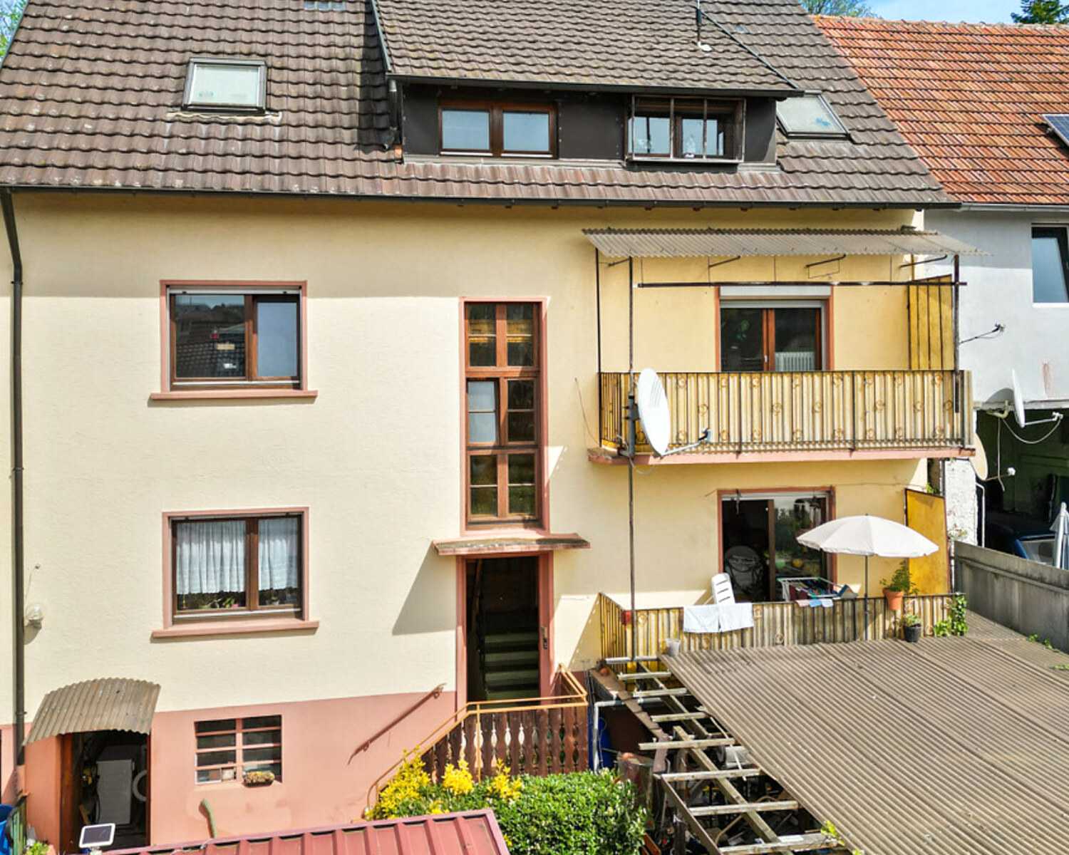 Mehrfamilienhaus in Kippenheim vor der Modernisierung: verwitterte Fassade, alte Holzbalkone